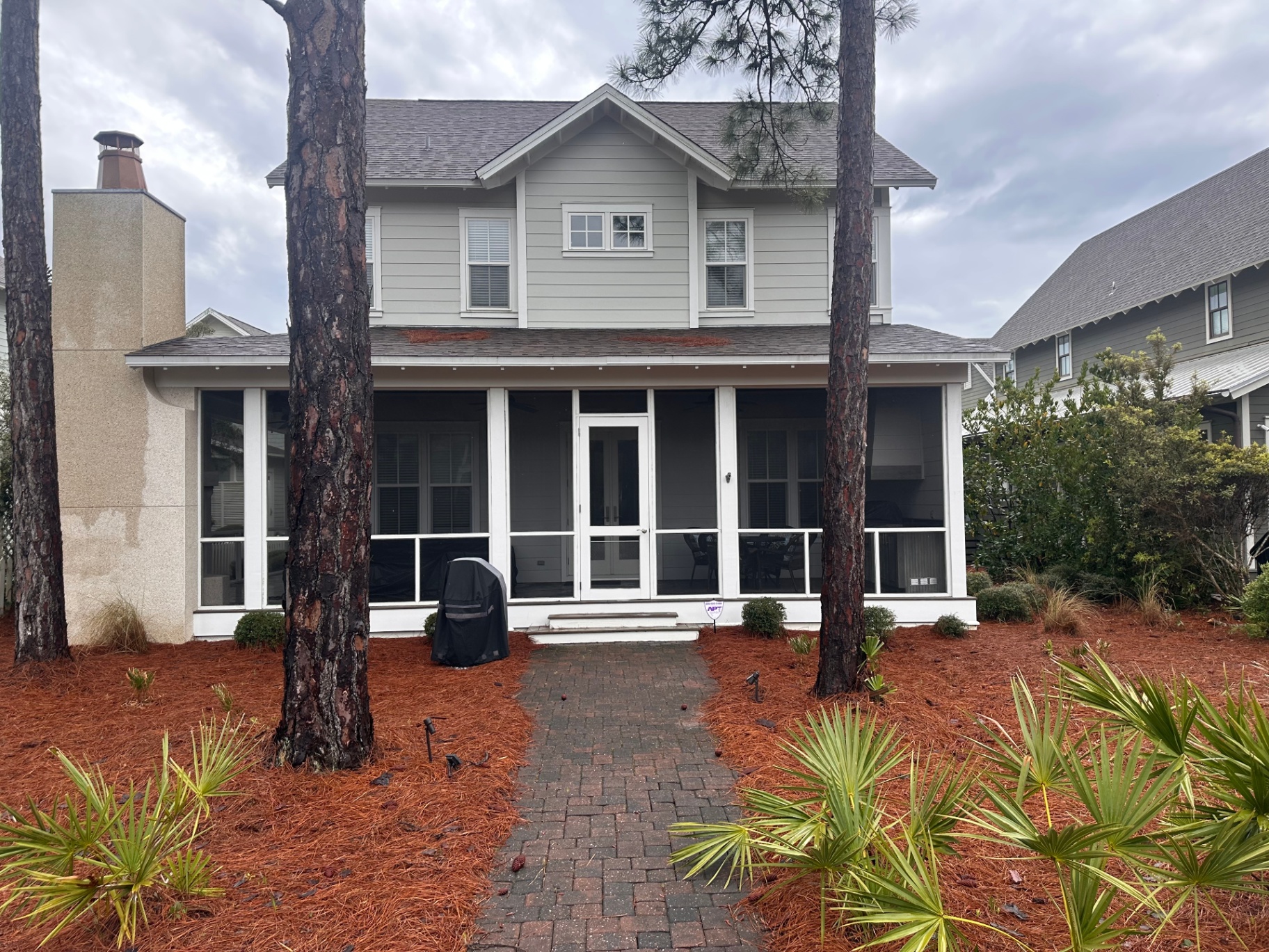 Rear Exterior with Screened Porch and Lush Surroundings